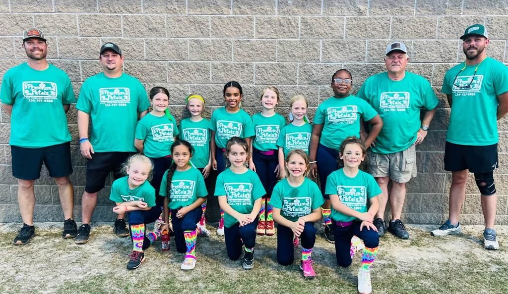 Youth softball team and coaches wearing green Premium Petals Landscape sponsor jerseys in the Wiregrass, AL